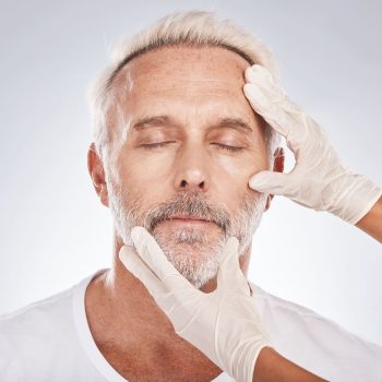 man-face-plastic-surgeon-hands-studio-background-skincare-collagen-medical-help-dermatology-anti-aging-grooming-zoom-cosmetic-surgery-mature-patient-model-facial-change-consult