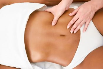 woman-receiving-abdomen-massage-spa-wellness-center